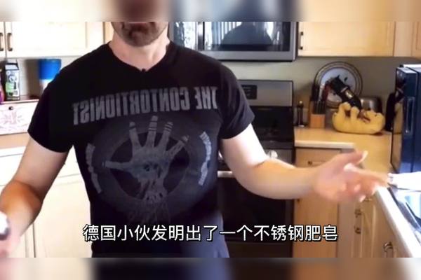 厨房水槽边,一块湿漉漉的灰色不锈钢肥皂放在白色台面上,旁边有几颗未洗的草莓