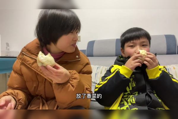 一碗淋着暗红色辣椒油和金黄榨菜粒的豆腐脑,勺子插在中间,背景是简陋的早餐店餐桌