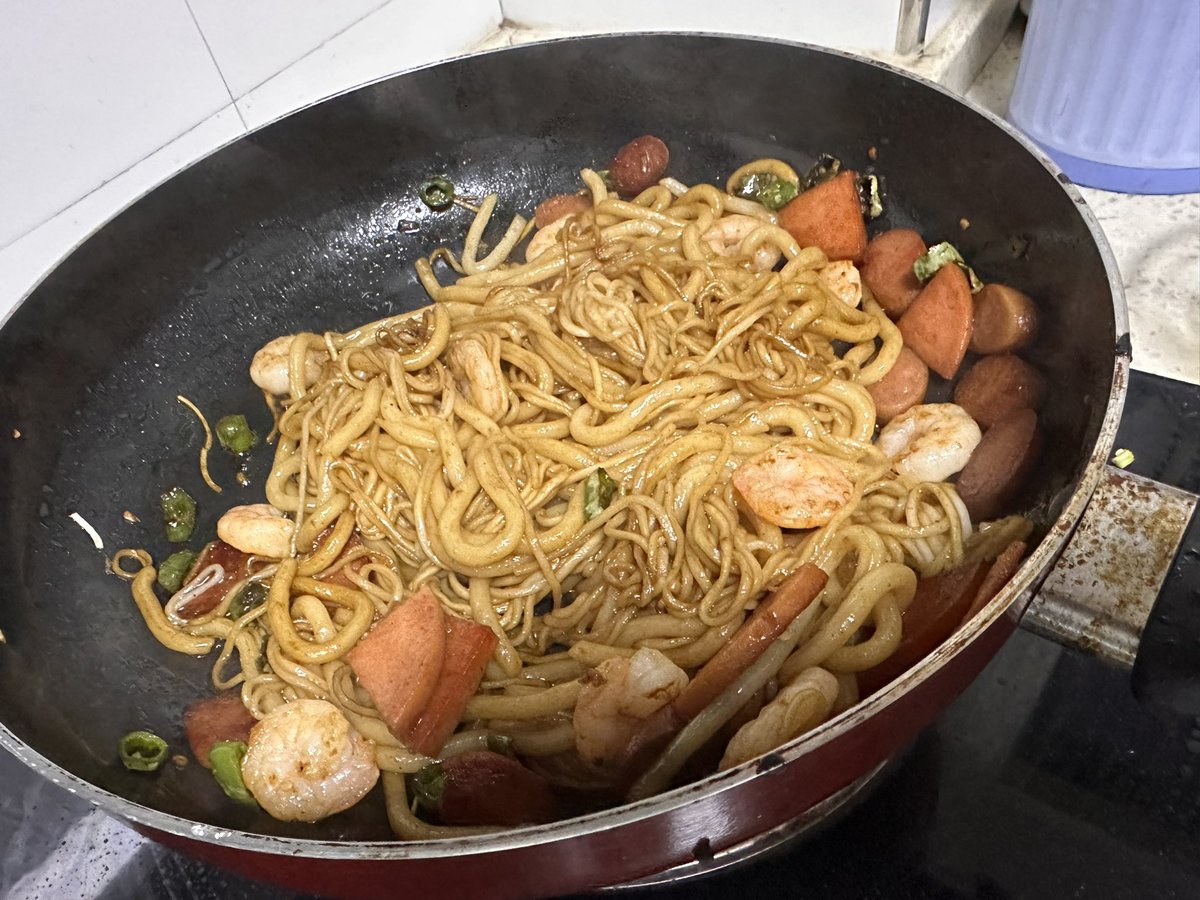 一口平底锅里，一条完整的鱼正在煎制，边缘金黄冒着小泡，用锅铲轻轻一推，鱼在锅底顺畅地滑动