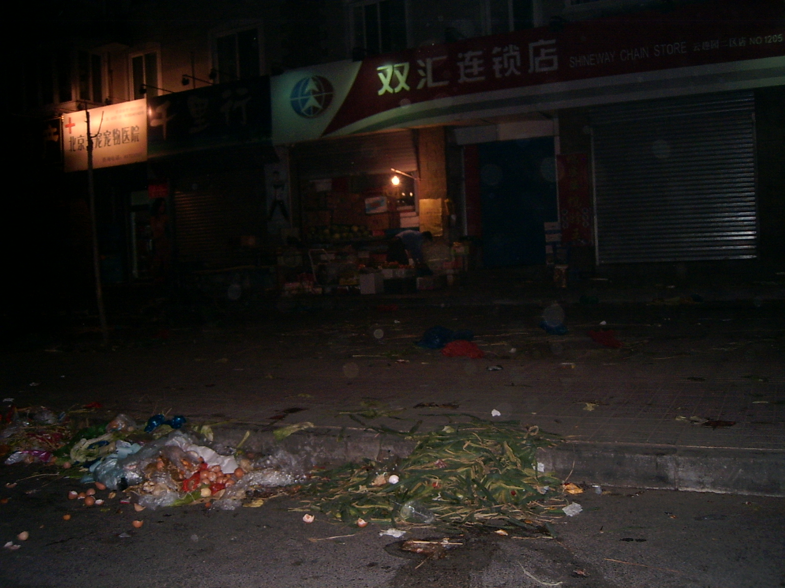从超市门口看向街道的视角，天空是金粉色，老式居民楼阳台飘着晾晒的衣物，一切笼罩在傍晚柔和的光线里