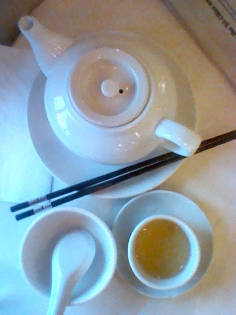 一张旧手机拍的照片，桌上是歪斜的盘子，里面是炒糊的蛋炒饭，旁边有双筷子随意扔着